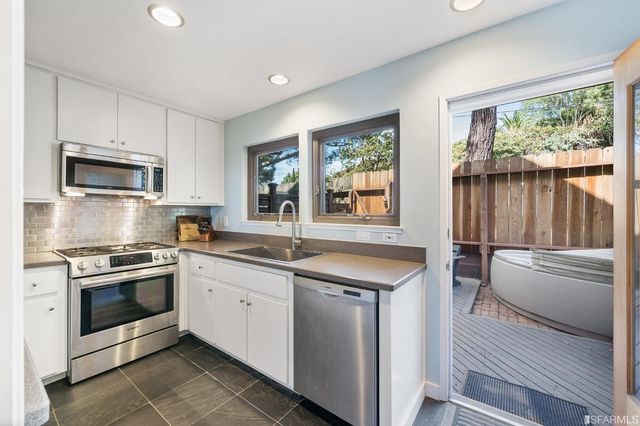 a kitchen with a stove a sink and a window