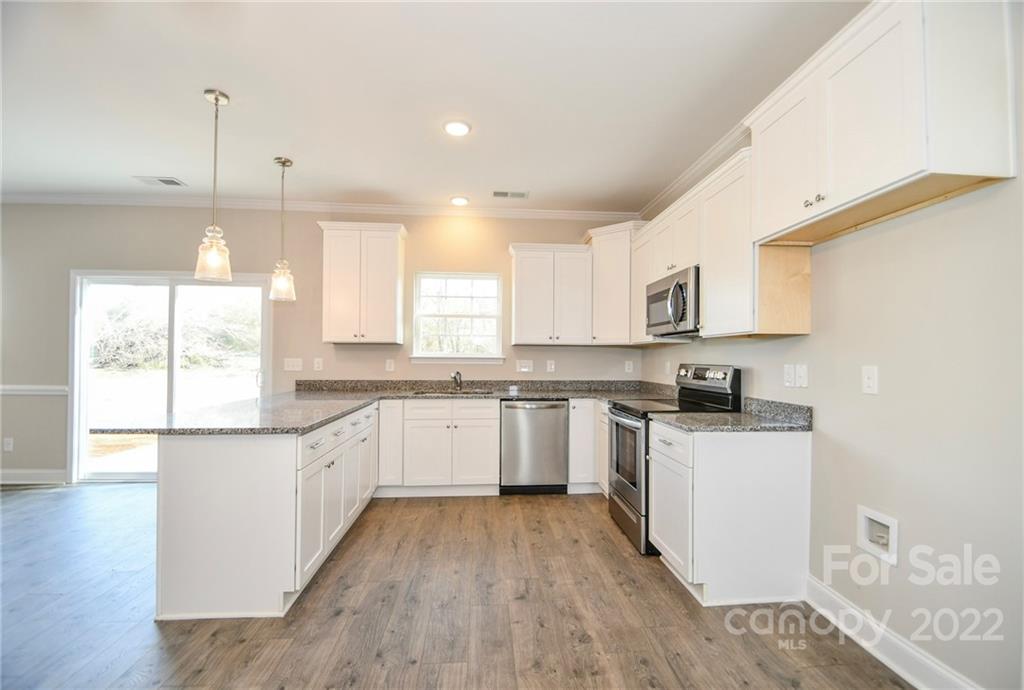 5413 Austin Road, Unit 4 Monroe, NC 28112 - Photo 11 of 22 a kitchen with granite countertop white cabinets a sink a window and stainless steel appliances