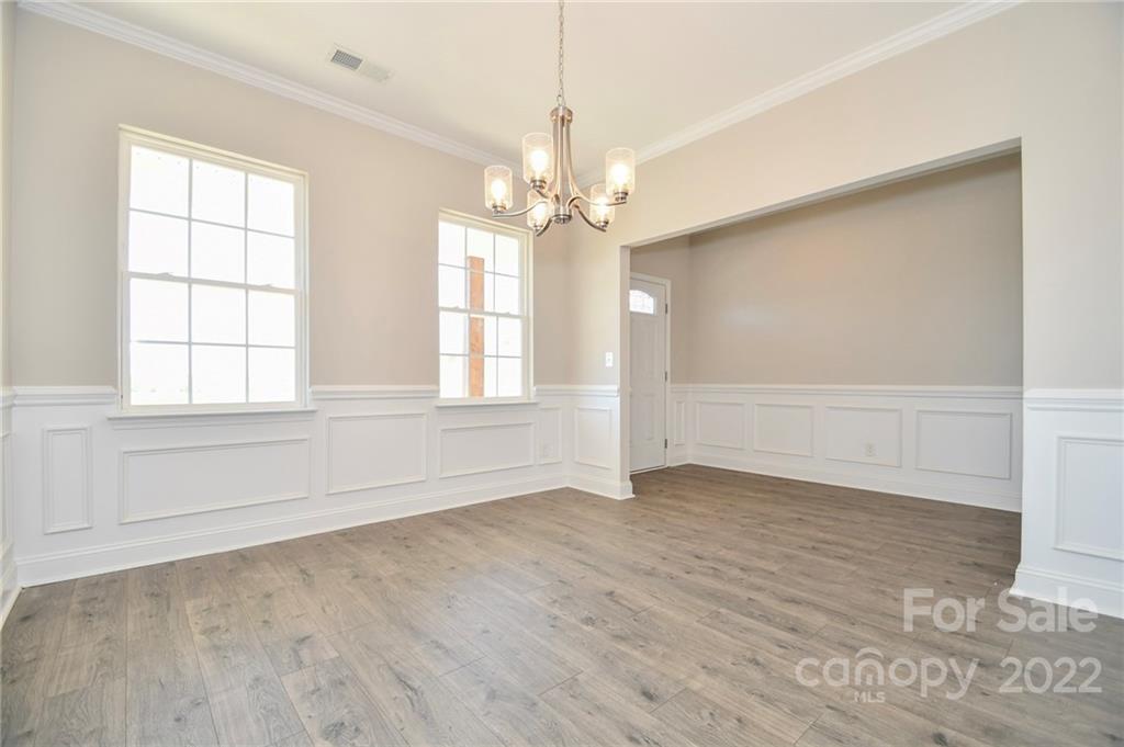 5413 Austin Road, Unit 4 Monroe, NC 28112 - Photo 5 of 22 an empty room with wooden floor chandelier and windows