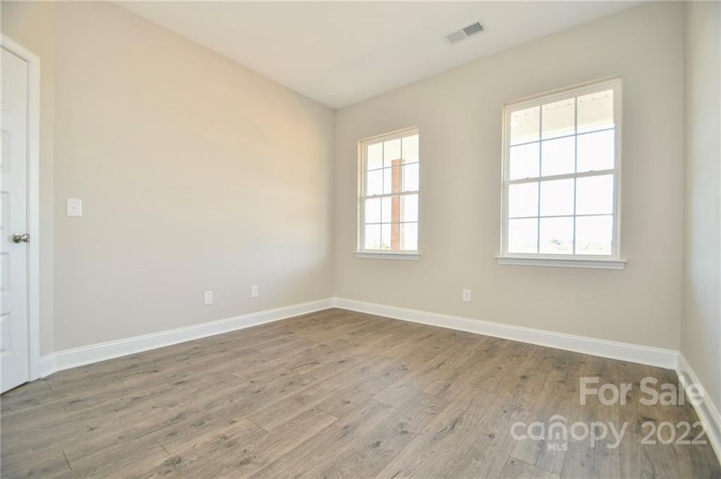 5413 Austin Road, Unit 4 Monroe, NC 28112 - Photo 6 of 22 an empty room with wooden floor and windows