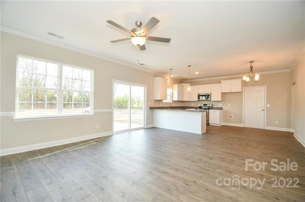 5413 Austin Road, Unit 4 Monroe, NC 28112 - Photo 7 of 22 a view of an empty room and kitchen with wooden floor