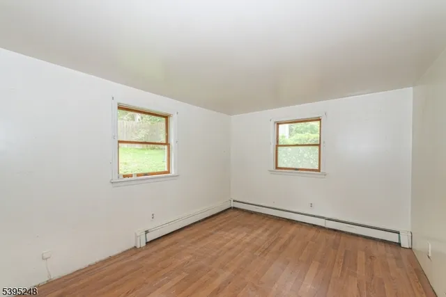 an empty room with a window and wooden floor