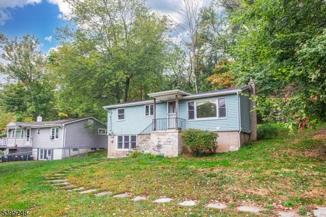 a view of a yard in front of a house with large trees