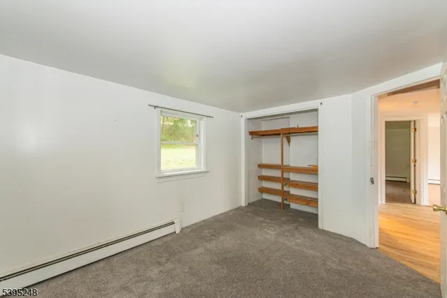 an empty room with closet and a window