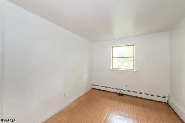 a view of a room with wooden floor and window