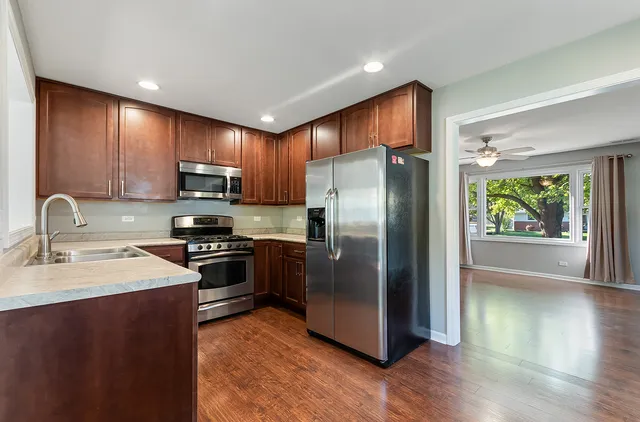 a kitchen with wooden cabinets a refrigerator and a sink