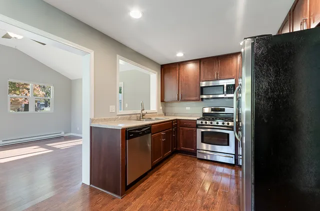 a kitchen with stainless steel appliances granite countertop a stove a refrigerator and a sink