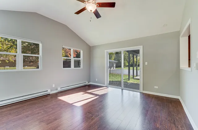 a view of a livingroom with wooden floor and a ceiling fan