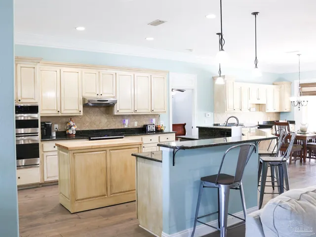 a kitchen with stainless steel appliances granite countertop a refrigerator sink and cabinets