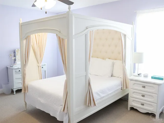 a spacious bedroom with a bed a table and a potted plant