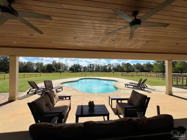 a view of swimming pool with outdoor seating and barbeque oven