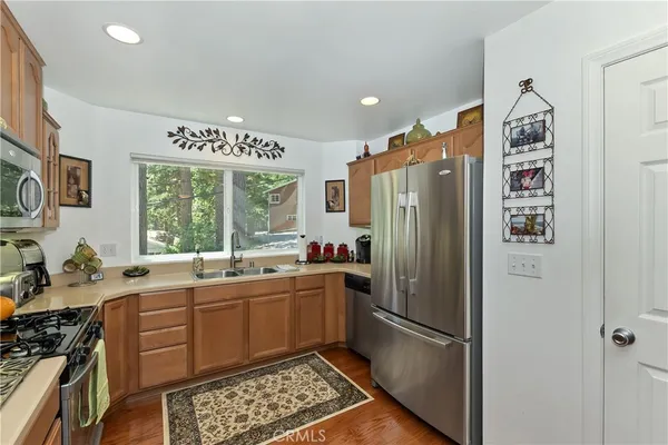 a kitchen with stainless steel appliances granite countertop a refrigerator and a sink