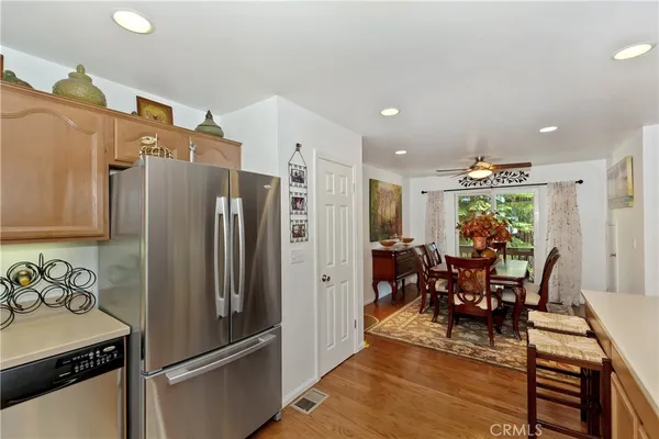 a kitchen with stainless steel appliances granite countertop a refrigerator and a dining table