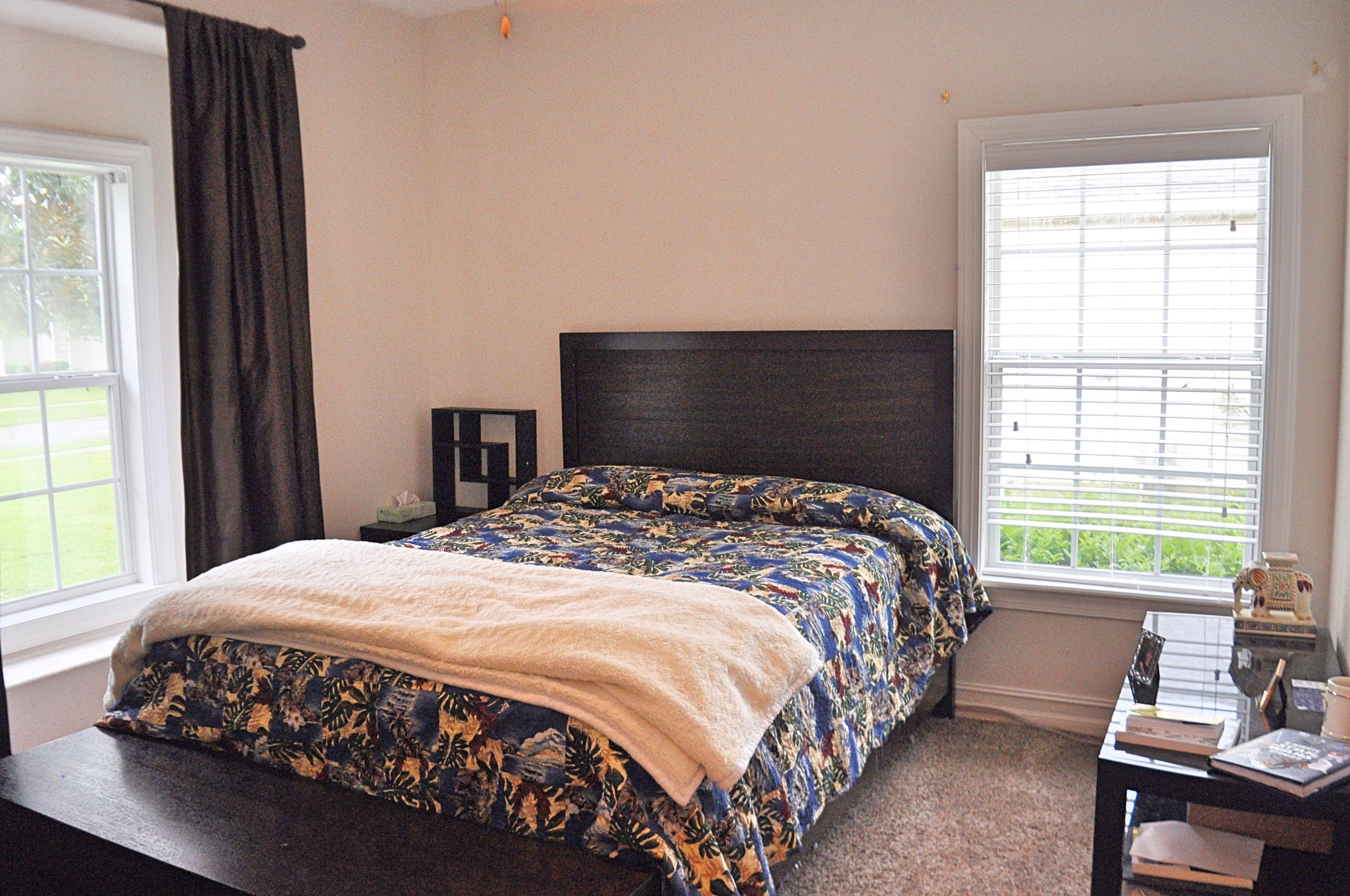 216 Mango Lane Freeport, FL 32439 - Photo 23 of 44 a bedroom with a bed two windows and a chair