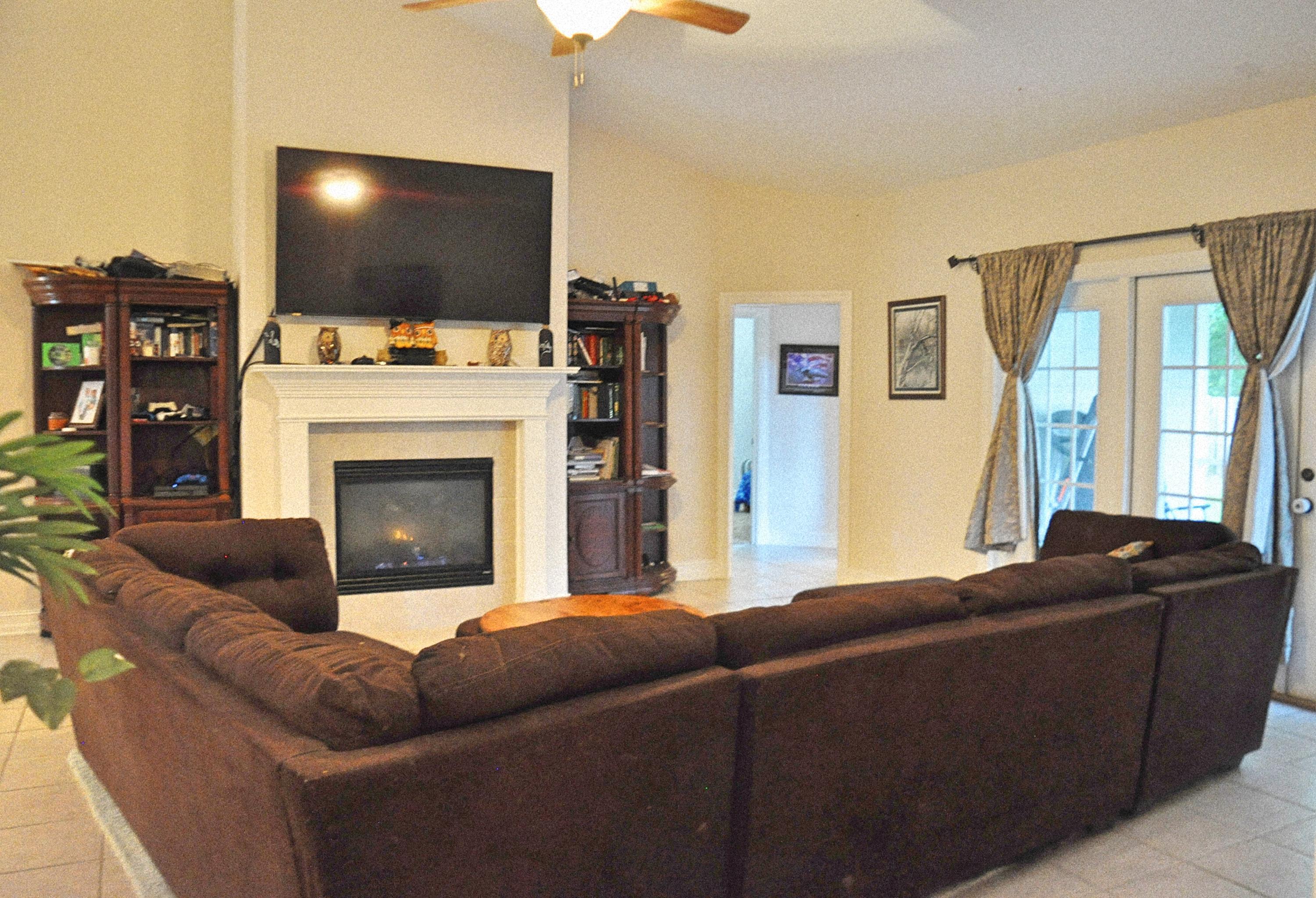 216 Mango Lane Freeport, FL 32439 - Photo 4 of 44 a living room with furniture a flat screen tv and a fireplace