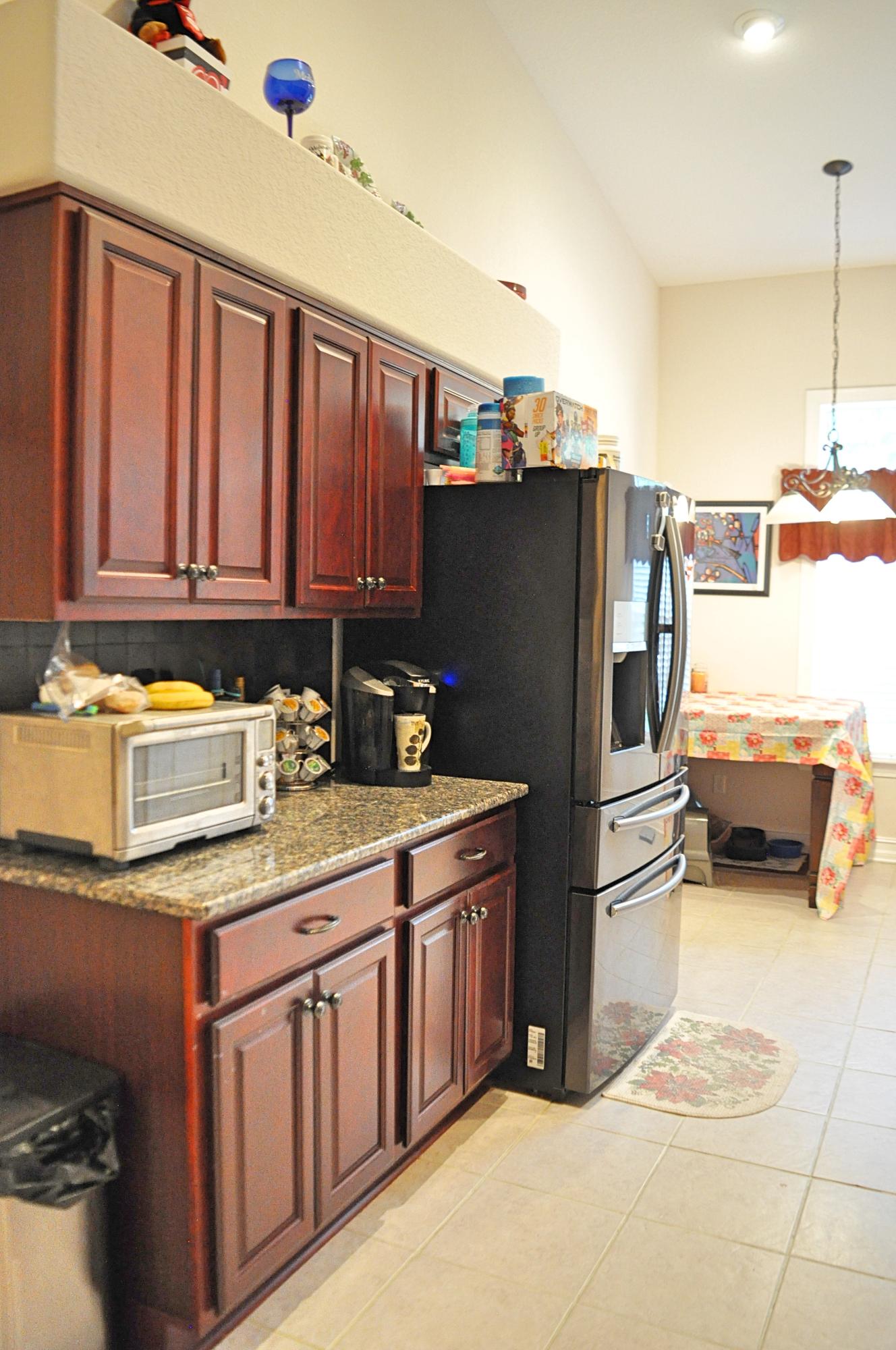 216 Mango Lane Freeport, FL 32439 - Photo 8 of 44 a kitchen with stainless steel appliances granite countertop a refrigerator a stove and a sink with wooden cabinets