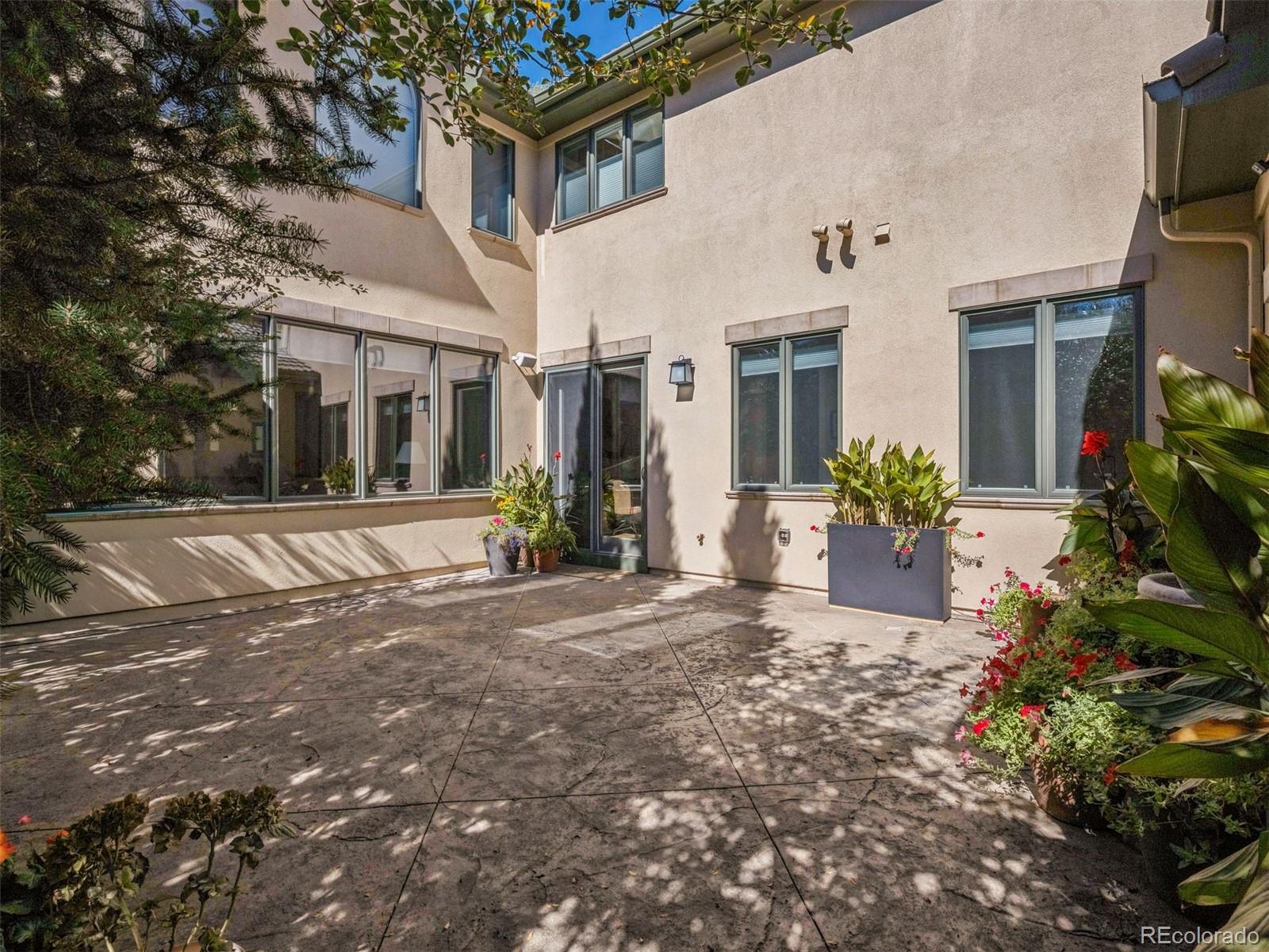 542 Adams Street Denver, CO 80206 - Photo 24 of 31 a view of a white house with a small yard and plants