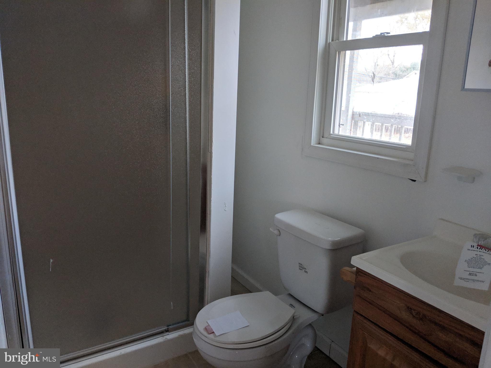 770 Elmhurst Road Severn, MD 21144 - Photo 13 of 26 a white toilet sitting next to a bathroom sink