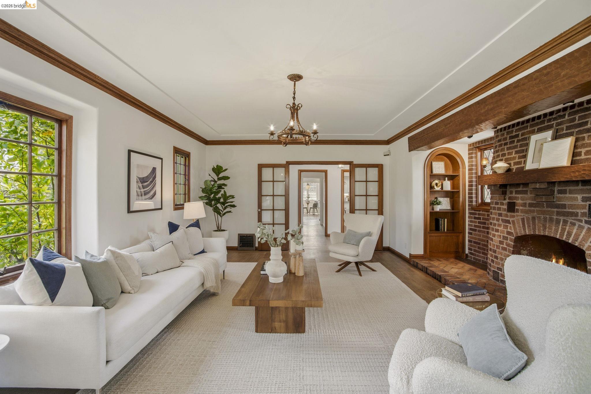 1087 Hubert Road Oakland, CA 94610 - Photo 47 of 67 Spacious living area featuring a brick fireplace with a wood mantle, hardwood flooring, and large windows with abundant natural light
