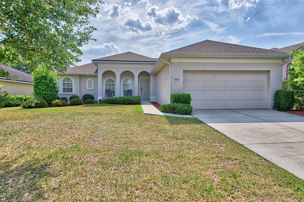 4960 Southwest 63rd Loop Ocala, FL 34474 - Photo 1 of 1 a front view of a house with yard and garage