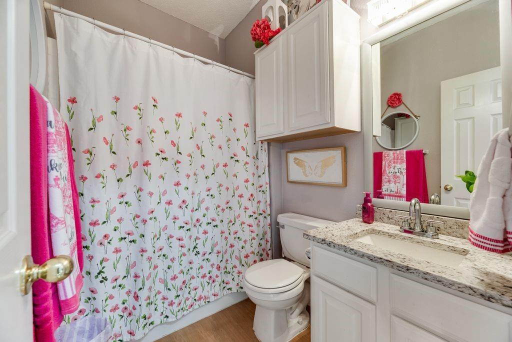 3205 Cape Cod Court Arlington, TX 76017 - Photo 26 of 30 a bathroom with a granite countertop sink and a toilet