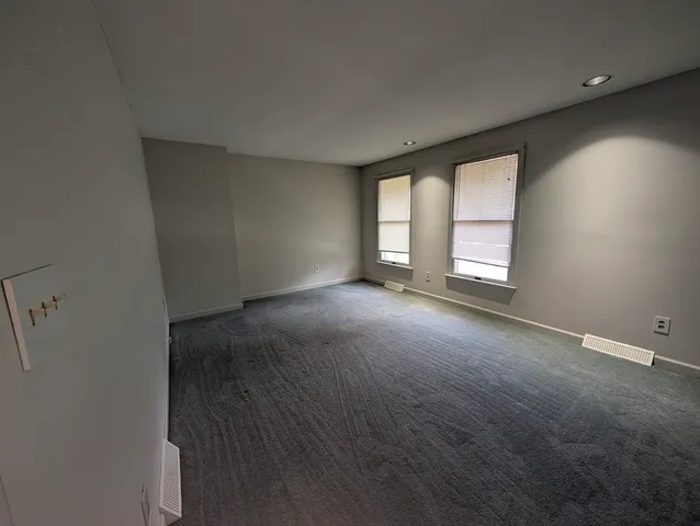 an empty room with windows and closet