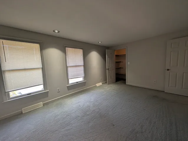 an empty room with a window and closet