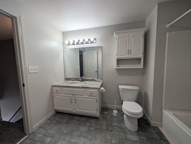 a spacious bathroom with a toilet sink and mirror