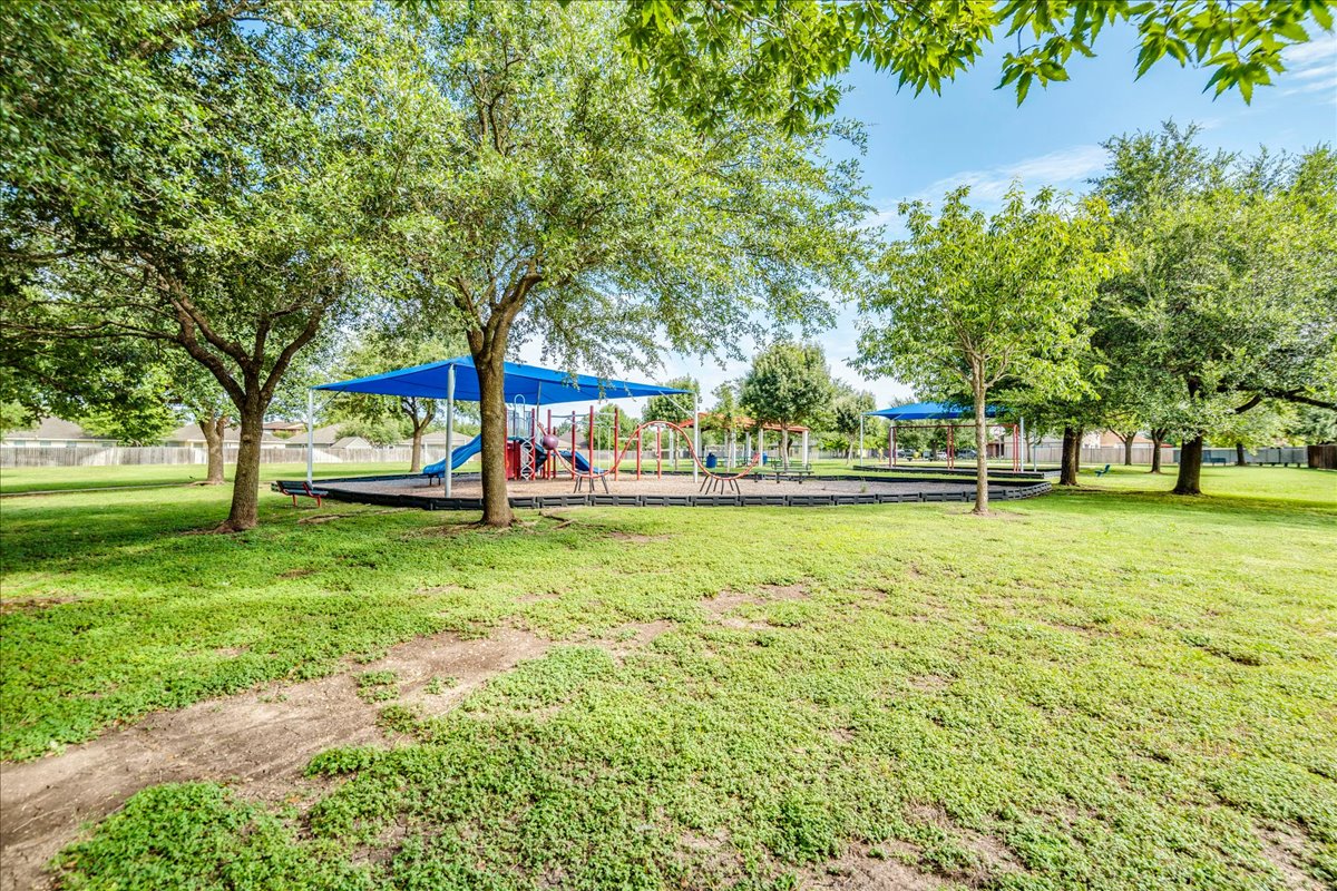 100 Easy Street Hutto, TX 78634 - Photo 32 of 36 A community green space offers shade trees and multiple play structures under vibrant blue canopies.