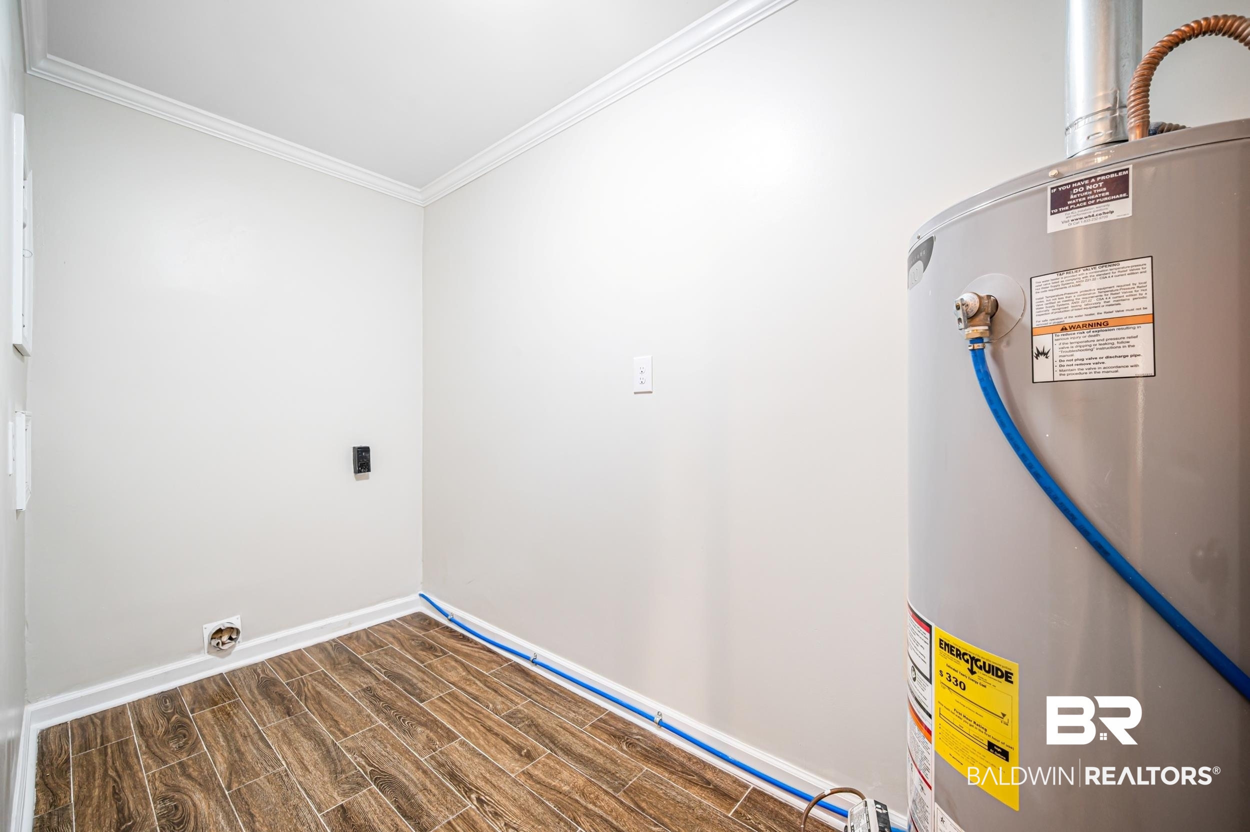 1605 Collier Avenue Bay Minette, AL 36507 - Photo 28 of 36 Washroom featuring gas water heater, ornamental molding, and wood finish floors