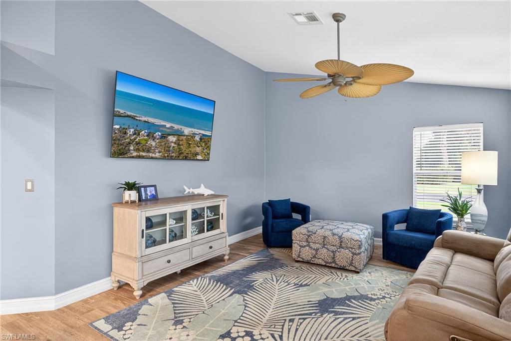 390 St Andrews Boulevard Naples, FL 34113 - Photo 13 of 42 Living area with wood finished floors, ceiling fan, and lofted ceiling