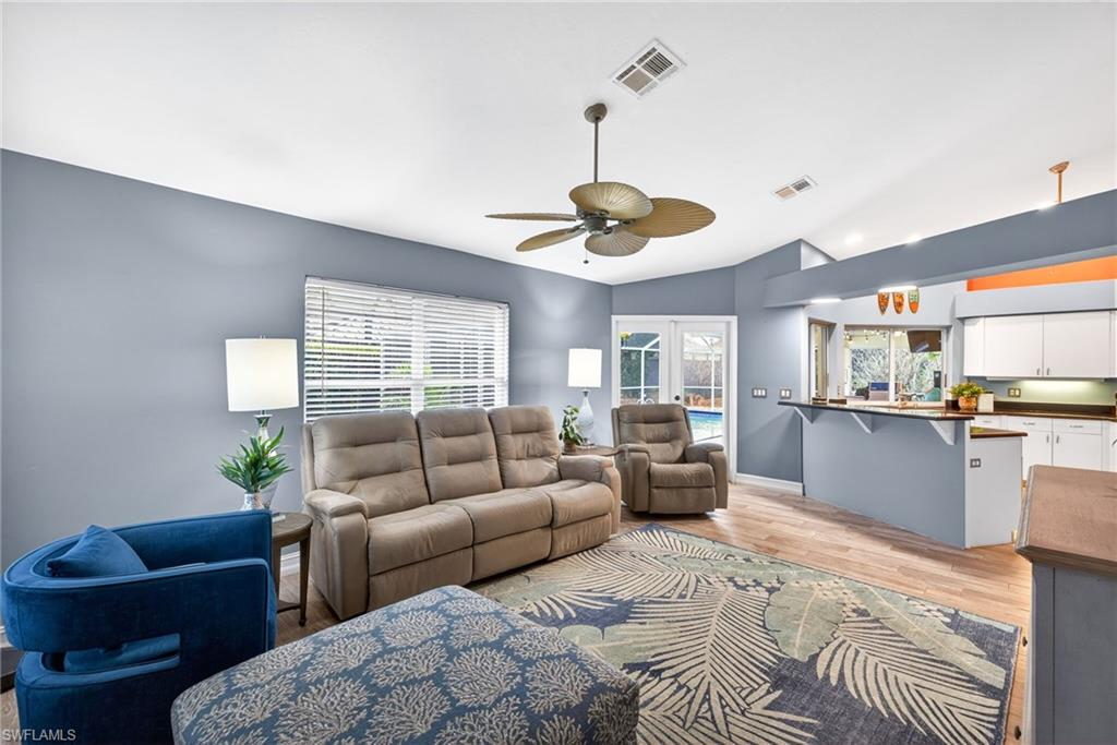 390 St Andrews Boulevard Naples, FL 34113 - Photo 14 of 42 Living area with light wood-type flooring, ceiling fan, french doors, and lofted ceiling