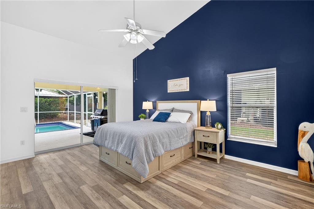 390 St Andrews Boulevard Naples, FL 34113 - Photo 15 of 42 Bedroom featuring a sunroom, access to exterior, vaulted ceiling, light wood finished floors, and ceiling fan