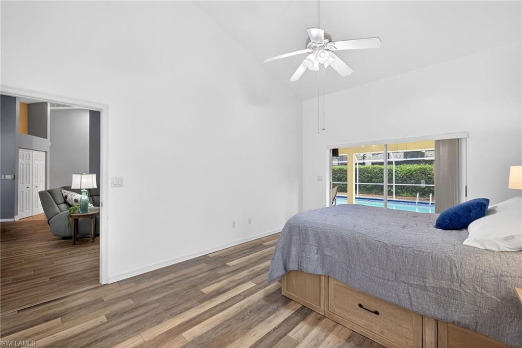 390 St Andrews Boulevard Naples, FL 34113 - Photo 16 of 42 Bedroom with dark wood finished floors, access to exterior, lofted ceiling, and ceiling fan