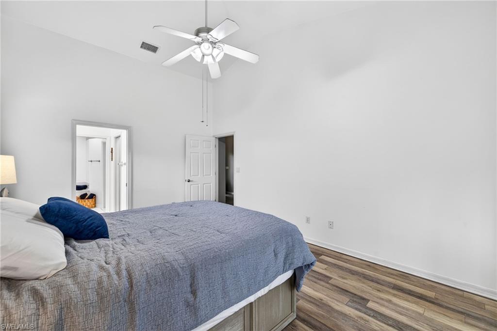 390 St Andrews Boulevard Naples, FL 34113 - Photo 17 of 42 Bedroom featuring dark wood-type flooring, ceiling fan, and vaulted ceiling