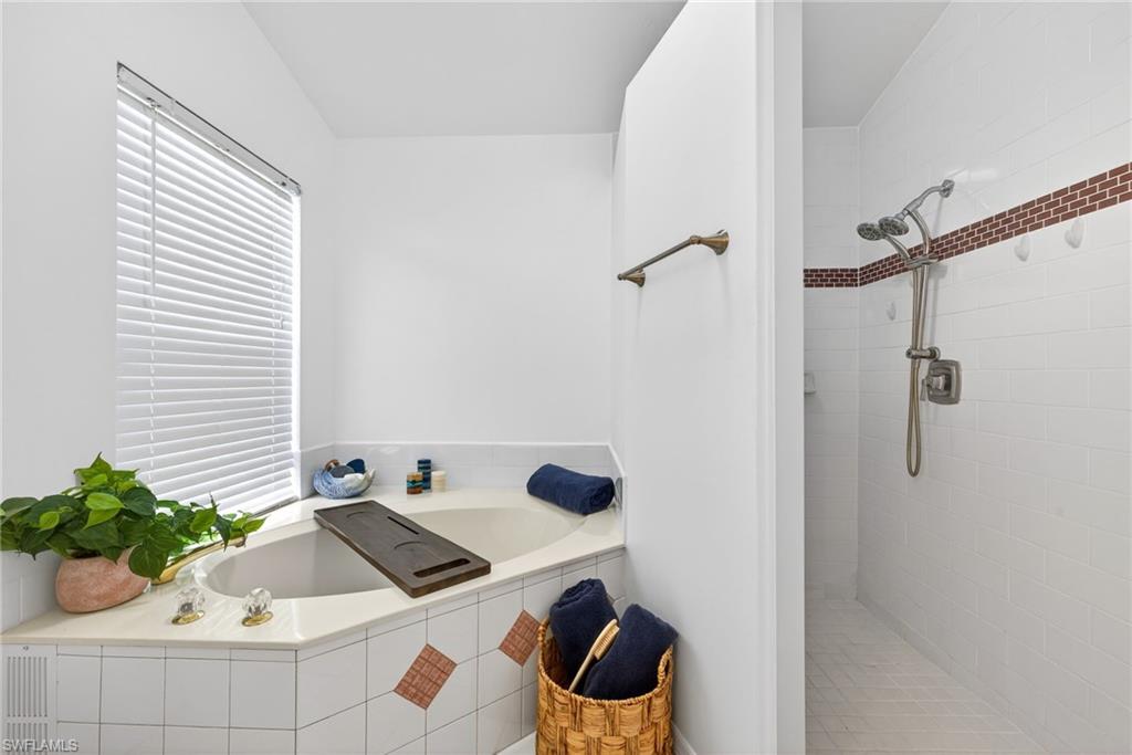 390 St Andrews Boulevard Naples, FL 34113 - Photo 19 of 42 Bathroom featuring a garden tub and a walk in shower