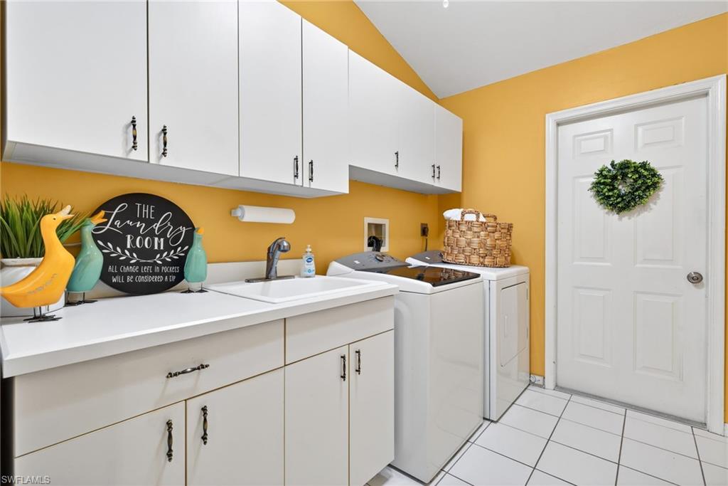 390 St Andrews Boulevard Naples, FL 34113 - Photo 24 of 42 Laundry area featuring light tile patterned flooring, cabinet space, washing machine and dryer.