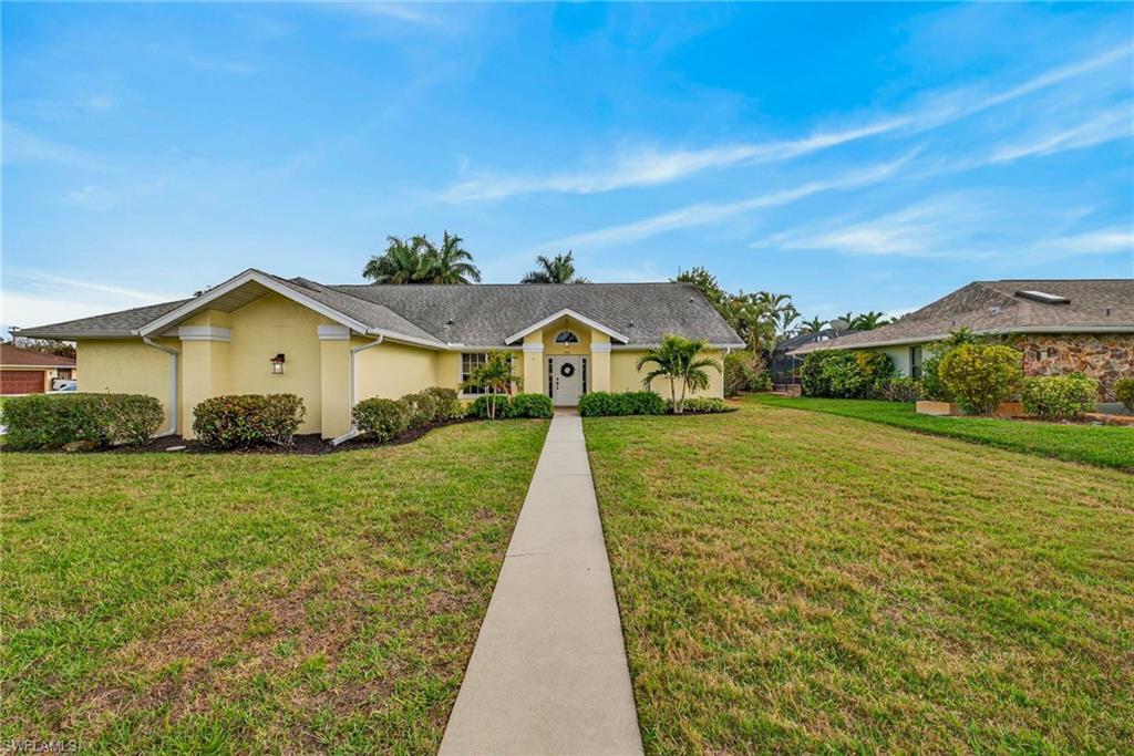 390 St Andrews Boulevard Naples, FL 34113 - Photo 3 of 42 Single story home with a front lawn and stucco siding