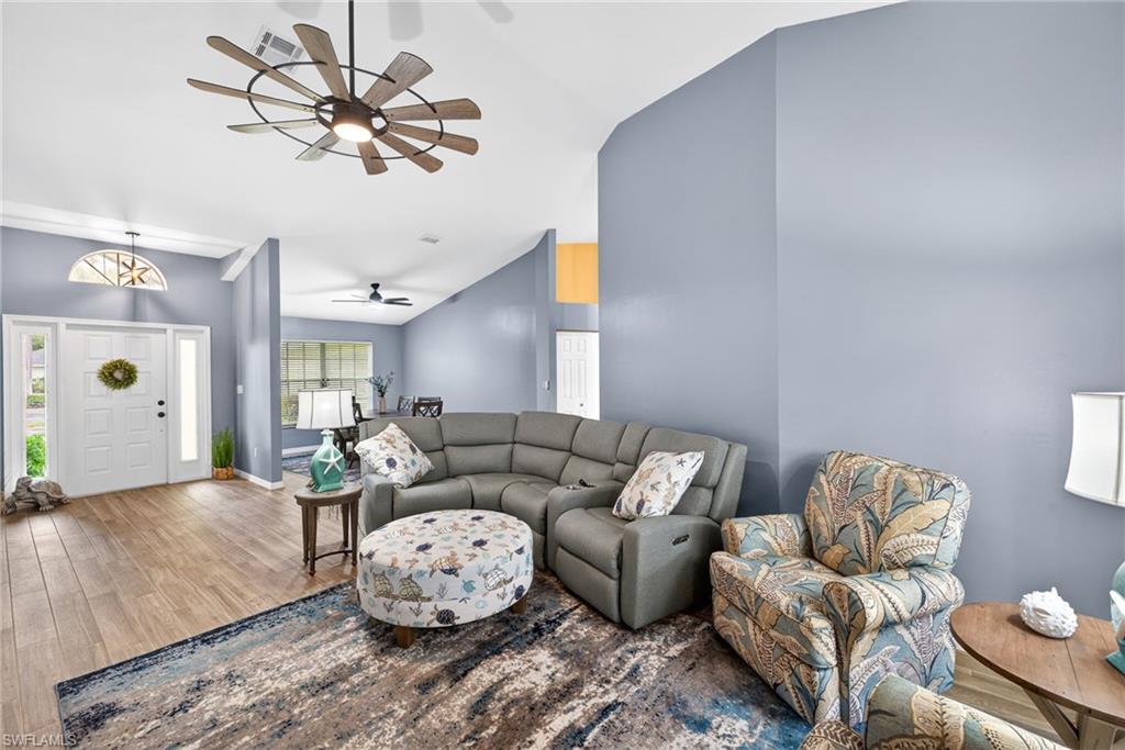 390 St Andrews Boulevard Naples, FL 34113 - Photo 7 of 42 Living area featuring wood finished floors, ceiling fan, and lofted ceiling