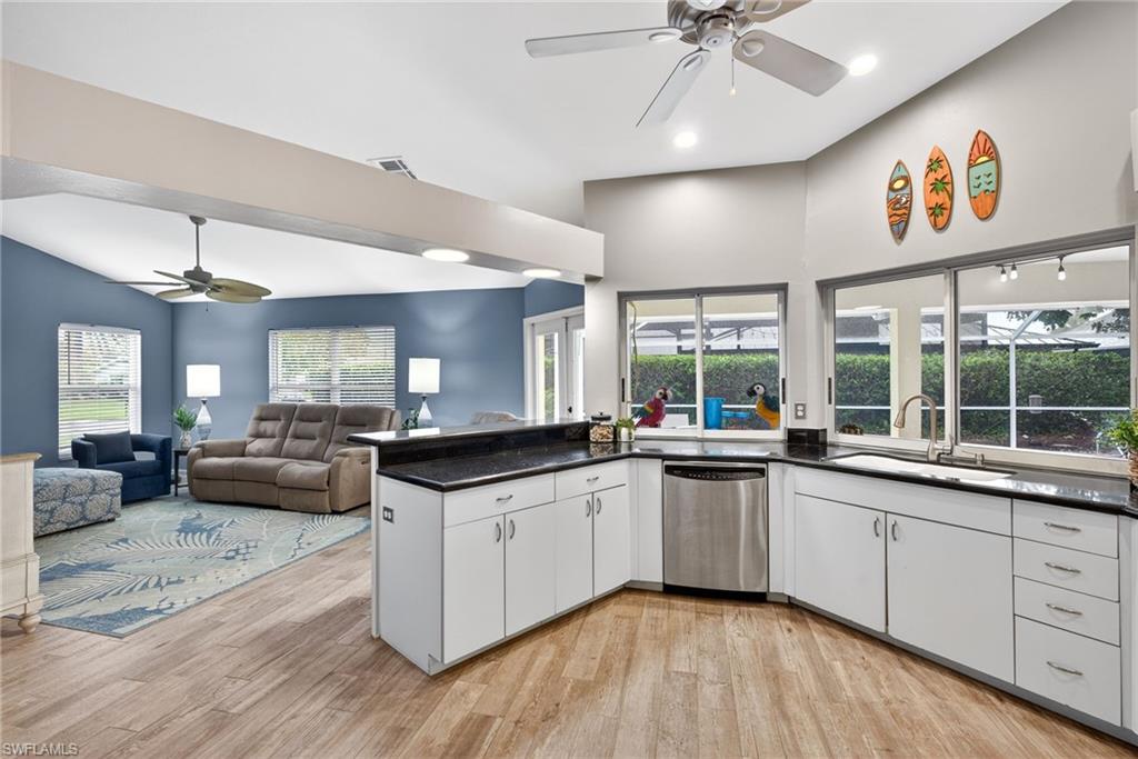 390 St Andrews Boulevard Naples, FL 34113 - Photo 41 of 42 Kitchen with a ceiling fan, white cabinets, open floor plan, dishwasher, and light wood finished floors