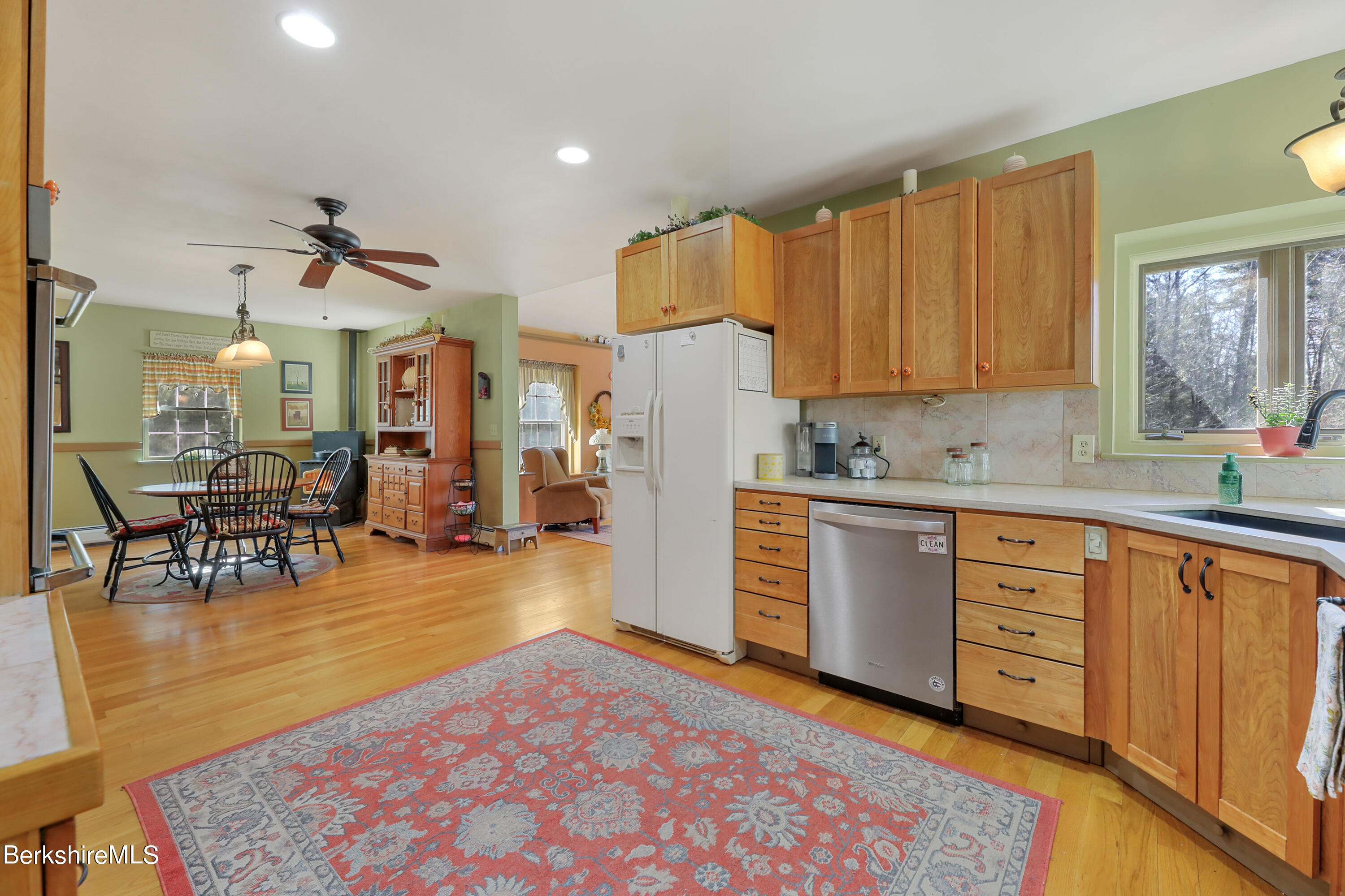 20 Ray Hubbard Road Otis, MA 01029 - Photo 22 of 59 a kitchen with stainless steel appliances granite countertop a refrigerator a stove a sink dishwasher and a dining table with wooden floor