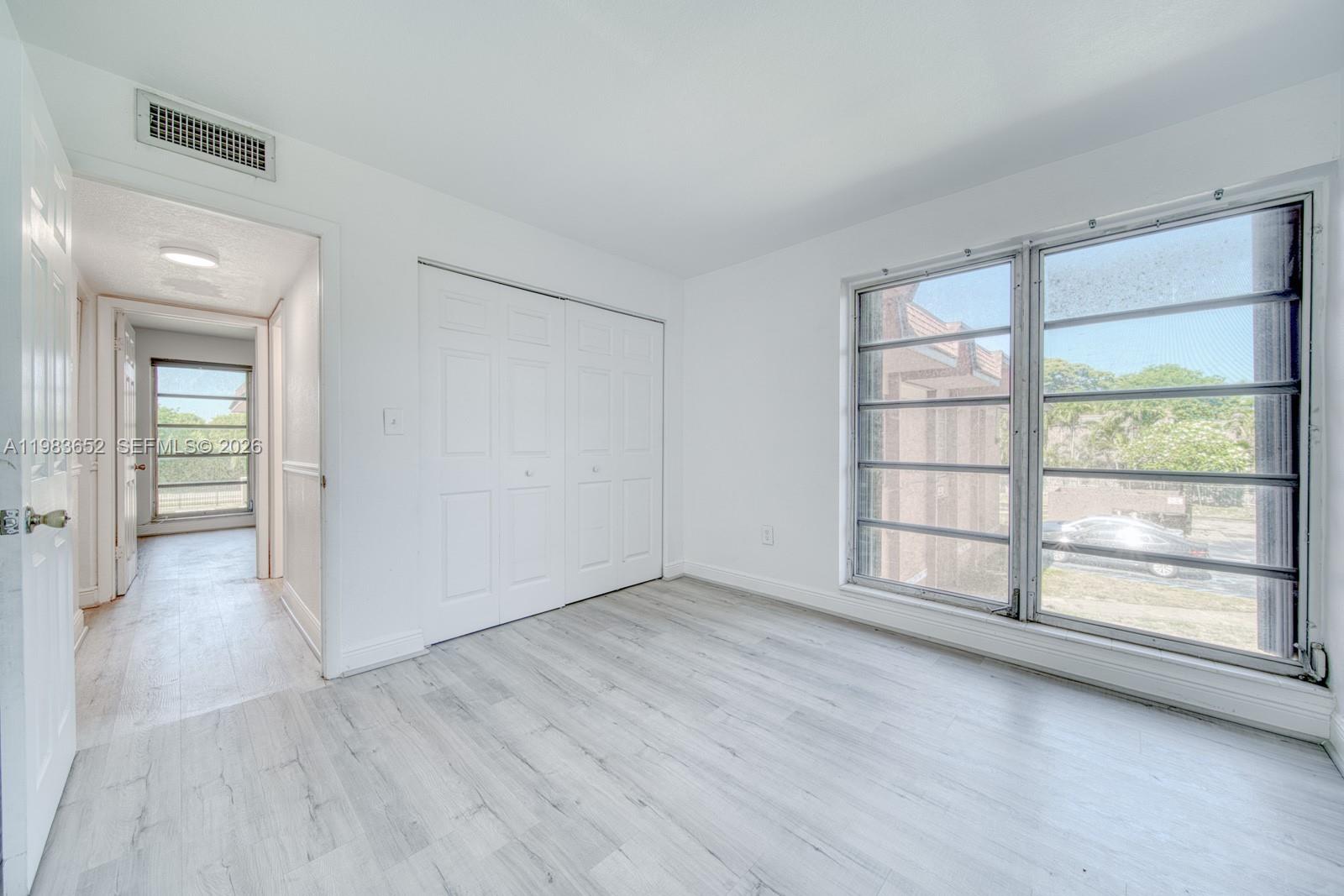 9459 Southwest 76th Street, Unit R5 Miami, FL 33173 - Photo 15 of 33 wooden floor in an empty room with a window