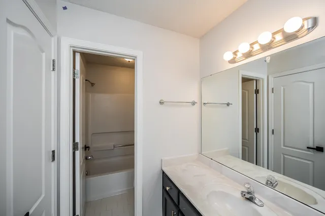 a bathroom with a sink vanity granite shower and a mirror