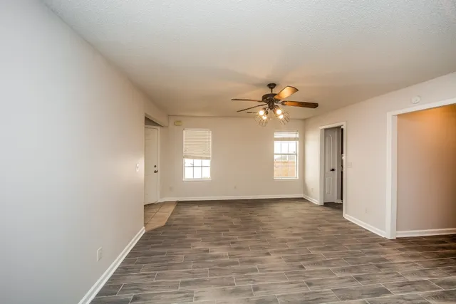 a view of empty room with window and wooden floor