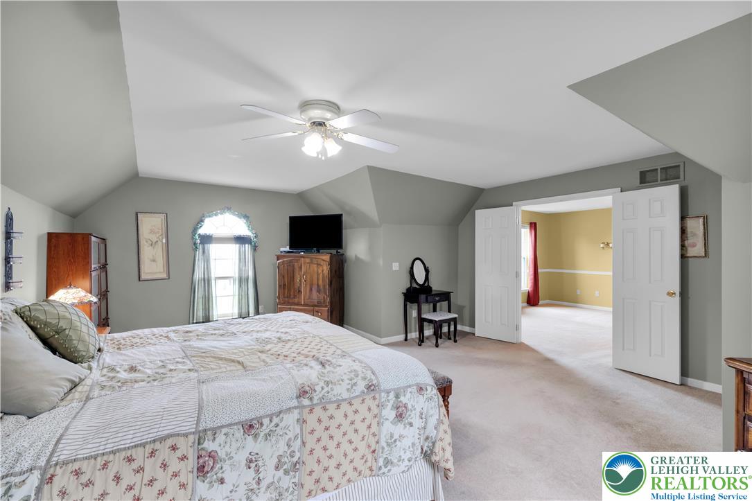 3830 McIntosh Drive Orefield, PA 18069 - Photo 16 of 36 a bedroom with a bed ceiling fan and a large window