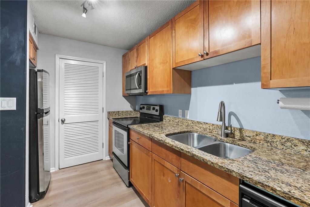 2657 Lenox Road Northeast, Unit L 163 Atlanta, GA 30324 - Photo 11 of 34 a kitchen with stainless steel appliances granite countertop a sink stove and cabinets