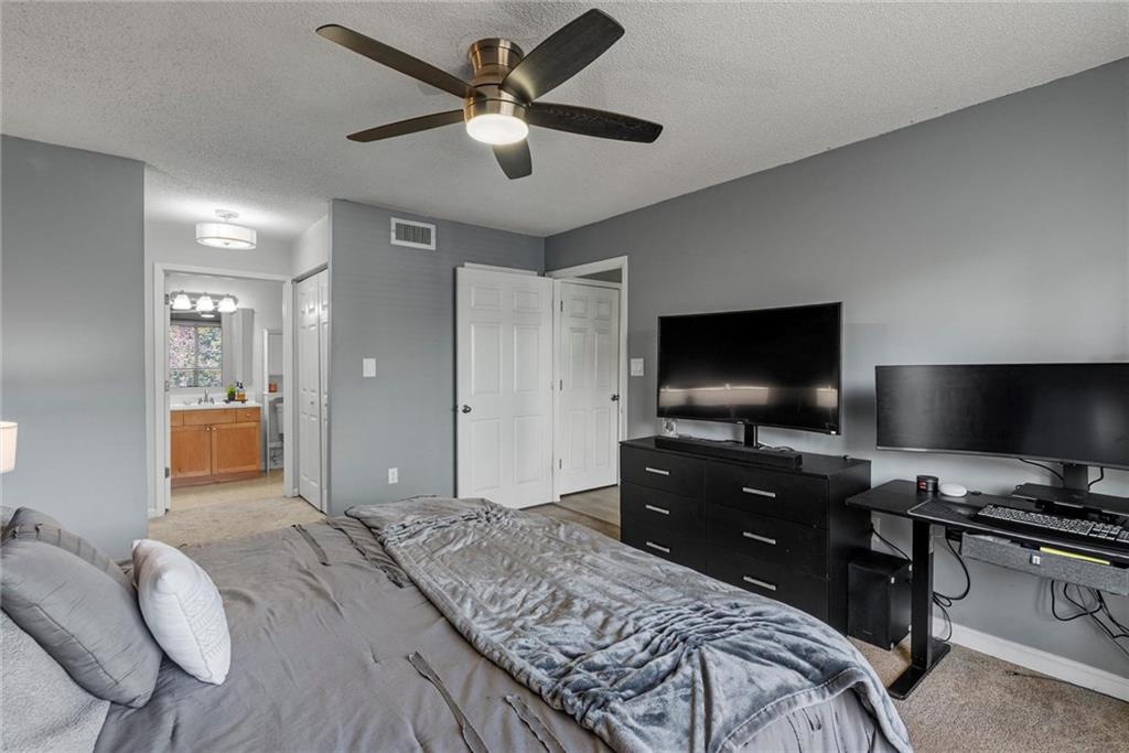 2657 Lenox Road Northeast, Unit L 163 Atlanta, GA 30324 - Photo 14 of 34 a bedroom with a bed and a flat screen tv