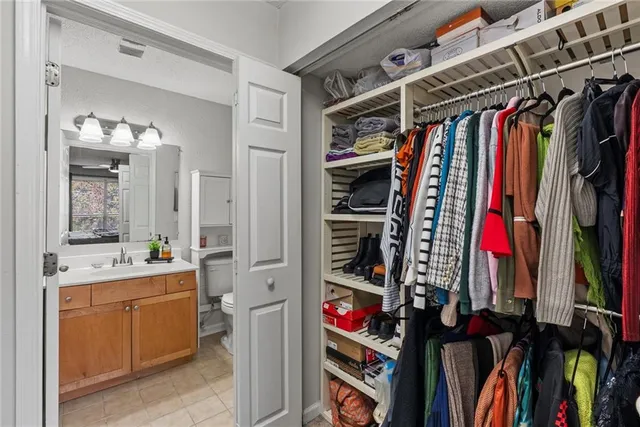 a view of walk in closet with clothes and shoes