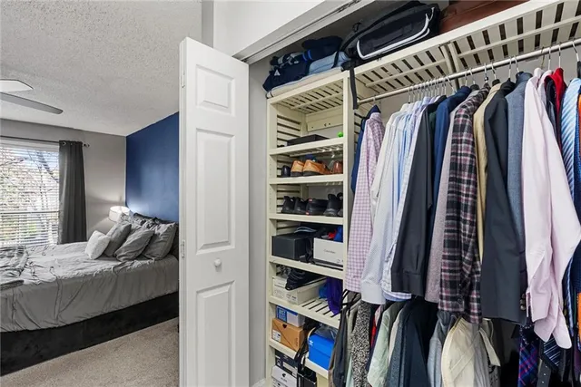 a view of walk in closet with clothes and shoes