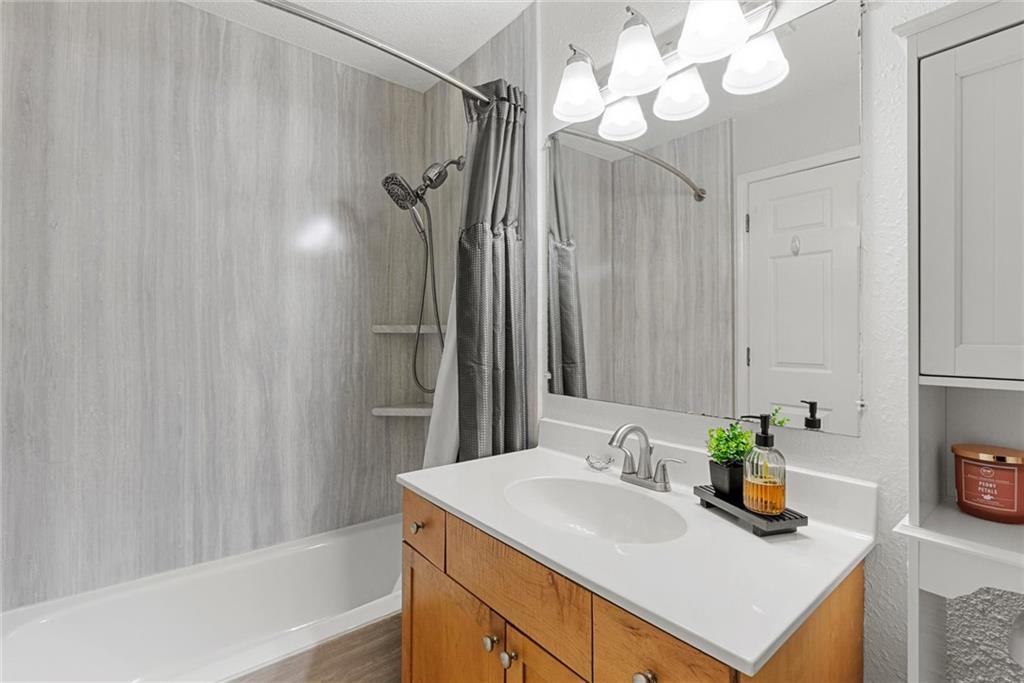 2657 Lenox Road Northeast, Unit L 163 Atlanta, GA 30324 - Photo 18 of 34 a bathroom with a sink a mirror and a shower curtain